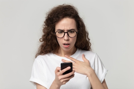 woman shocked reading phone