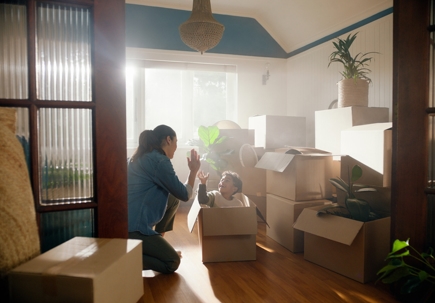 Mother high fiving son with moving boxes