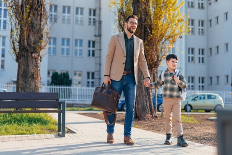 Father taking his son to school, holding hands