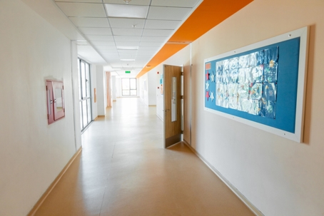 Empty school hallway with classroom doors and bulletin boards, representing the setting where drug possession cases involving minors may occur in Virginia.